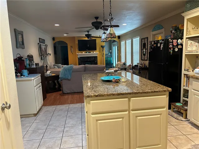 a kitchen with kitchen island granite countertop appliances cabinets and a counter top space