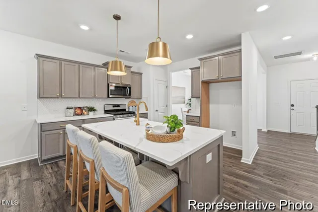 a kitchen with kitchen island white cabinets and stainless steel appliances