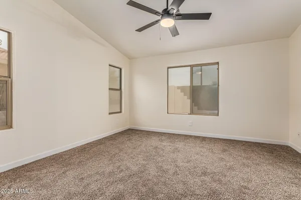 an empty room with fan and windows