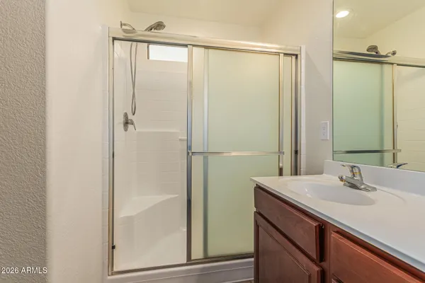 a bathroom with a shower sink and mirror