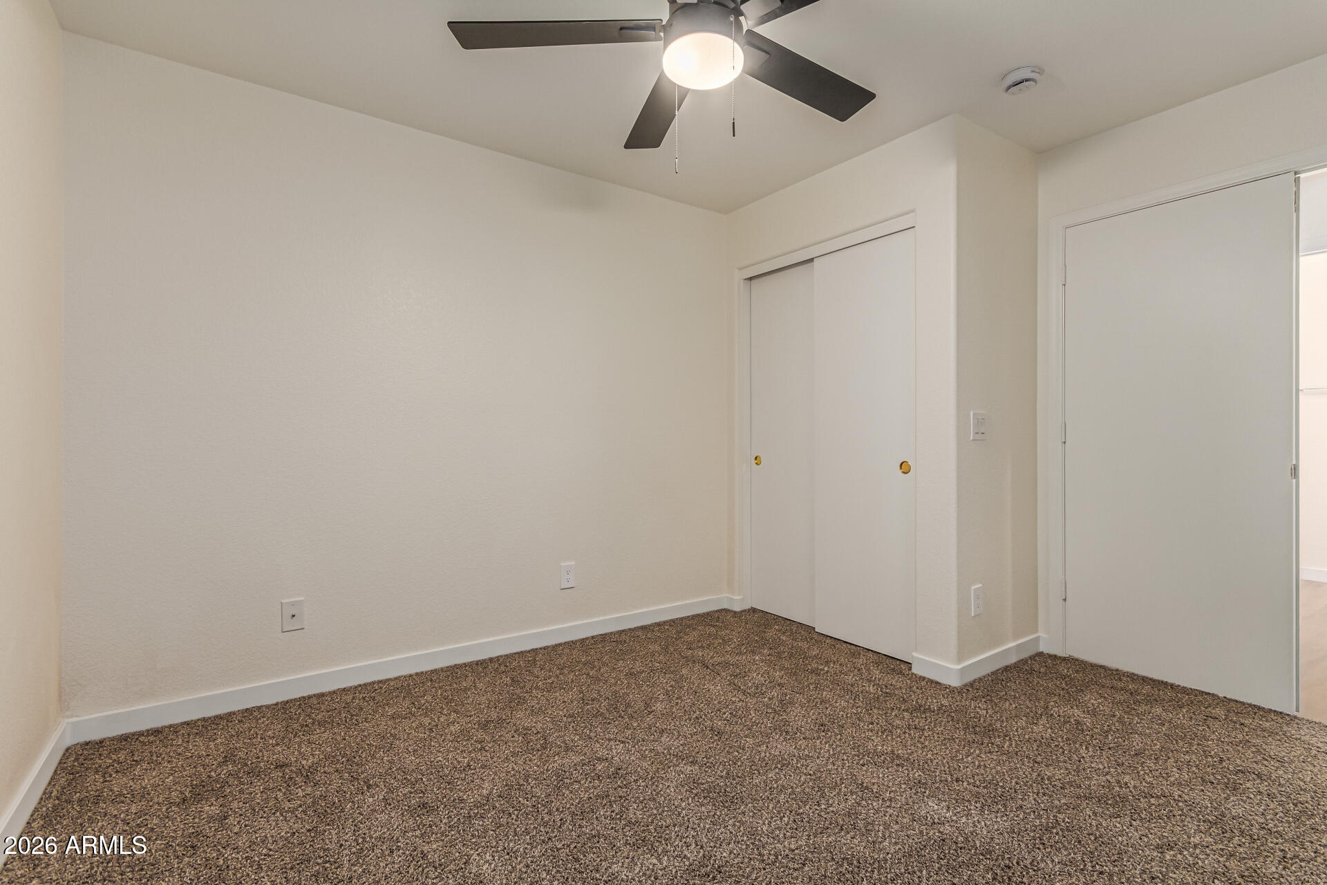 2101 South Meridian Road, Unit 428 Apache Junction, AZ 85120 - Photo 20 of 23 an empty room with a chandelier fan and windows