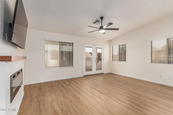 a view of an empty room with a window and wooden floor