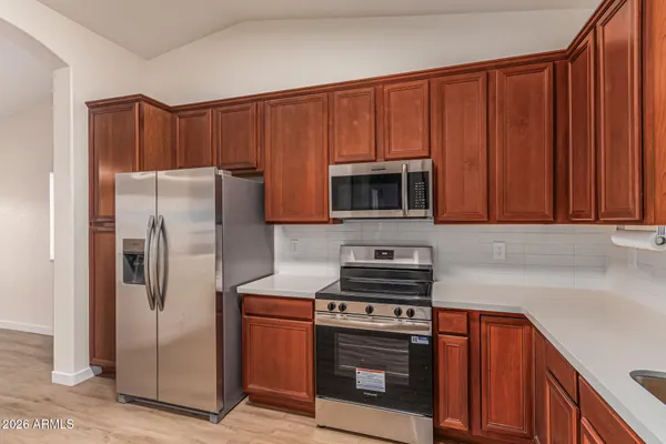 a kitchen with stainless steel appliances granite countertop a refrigerator stove and microwave
