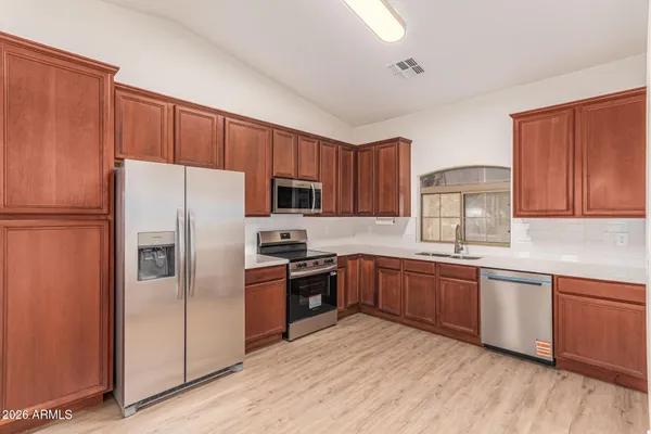 a kitchen with stainless steel appliances granite countertop a refrigerator stove top oven and sink