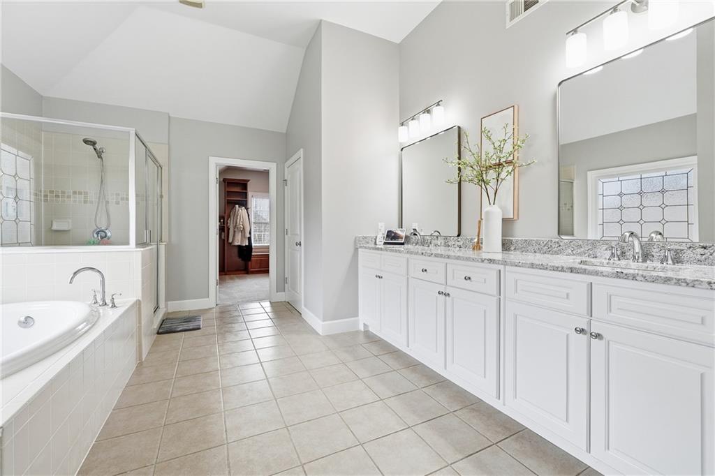 2555 Weddington Ridge Northeast Marietta, GA 30068 - Photo 27 of 65 a spacious en suite bathroom with a granite countertop sink mirror and bathtub
