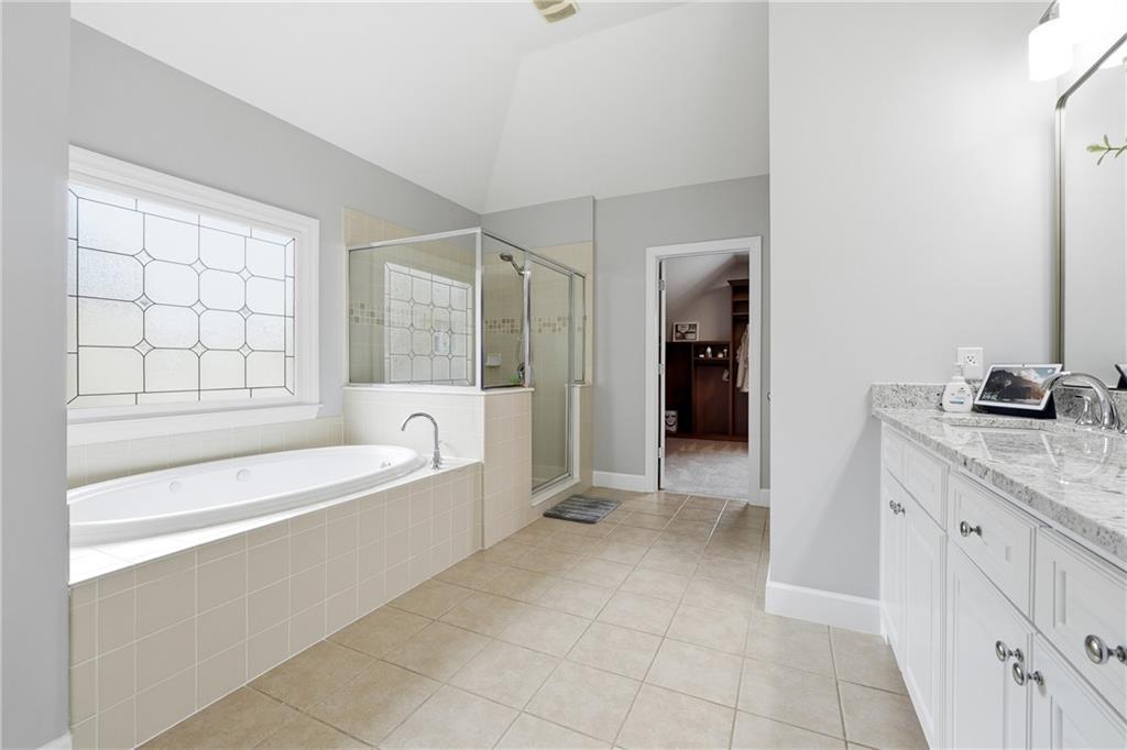 2555 Weddington Ridge Northeast Marietta, GA 30068 - Photo 28 of 65 a spacious bathroom with a granite countertop tub sink and mirror