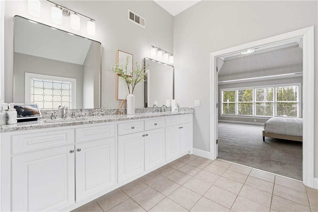 2555 Weddington Ridge Northeast Marietta, GA 30068 - Photo 31 of 65 a spacious bathroom with a granite countertop sink a mirror and a bathtub