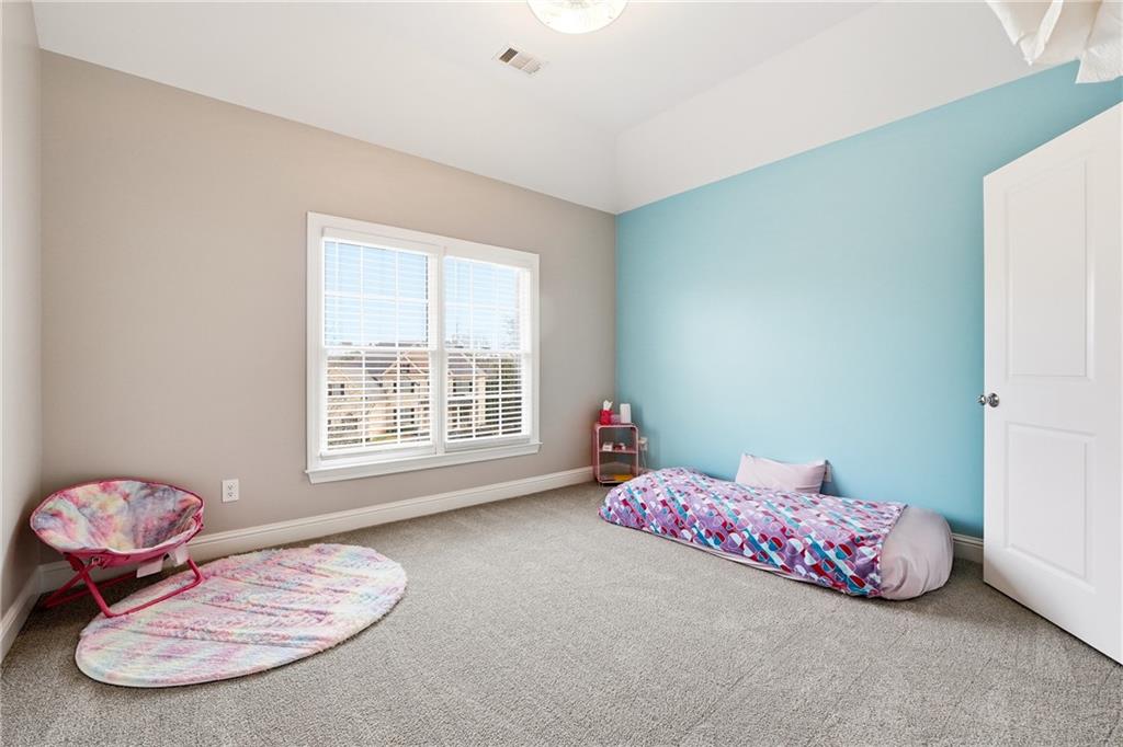 2555 Weddington Ridge Northeast Marietta, GA 30068 - Photo 41 of 65 a bedroom with a bed and a chandelier