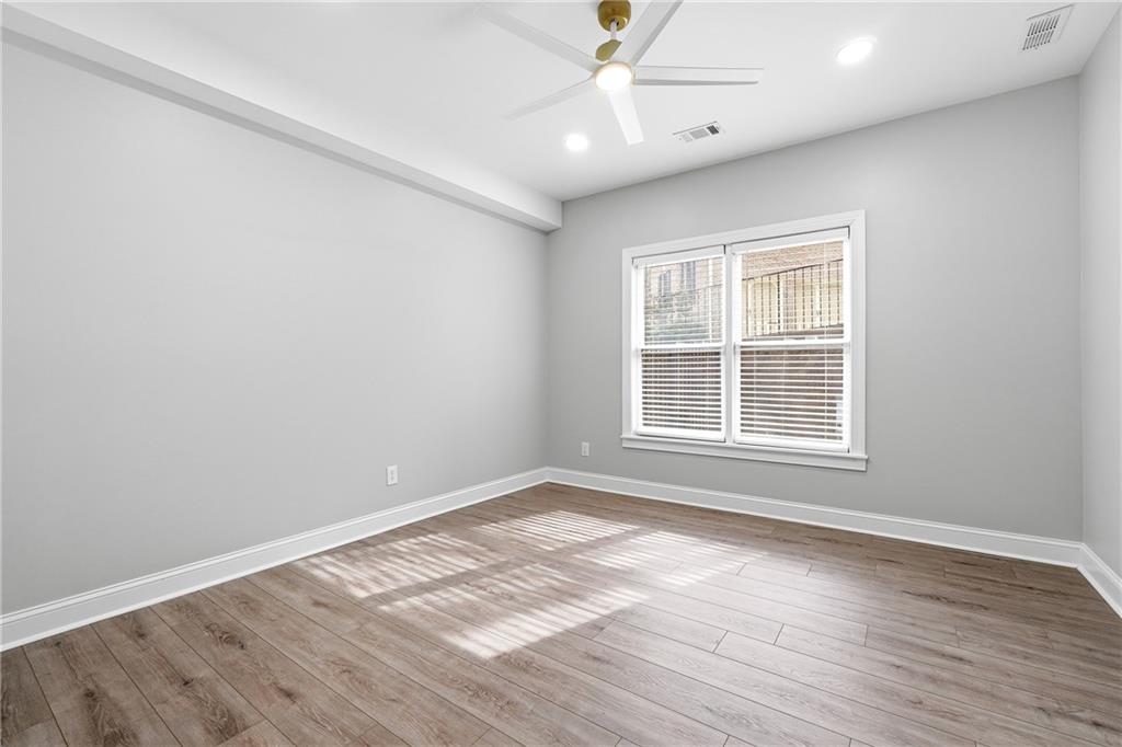 2555 Weddington Ridge Northeast Marietta, GA 30068 - Photo 46 of 65 an empty room with wooden floor chandelier fan and windows