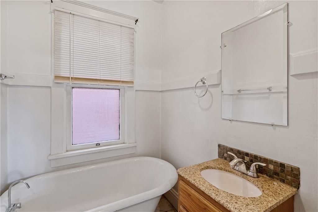 214 Sarah Street McKees Rocks, PA 15136 - Photo 19 of 28 a bathroom with a granite countertop sink a mirror and a bathtub