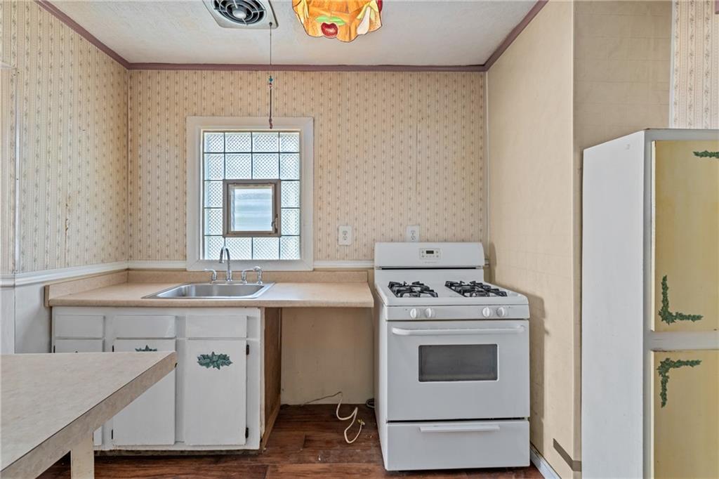 214 Sarah Street McKees Rocks, PA 15136 - Photo 9 of 28 a kitchen with a stove a sink and a refrigerator