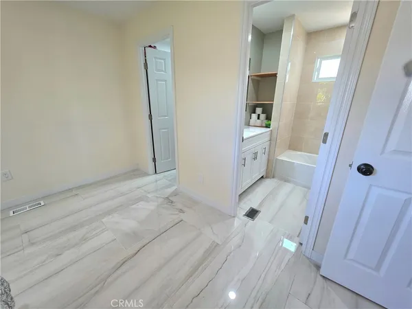 a bedroom with wooden floor and window