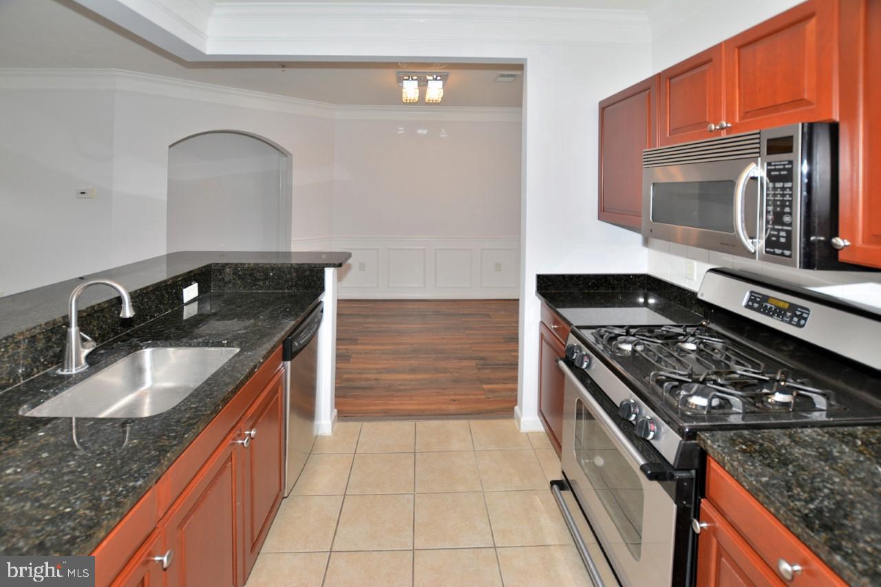 508 Sunset View Terrace Southeast, Unit 205 Leesburg, VA 20175 - Photo 12 of 28 a kitchen with stainless steel appliances granite countertop a sink stove and cabinets