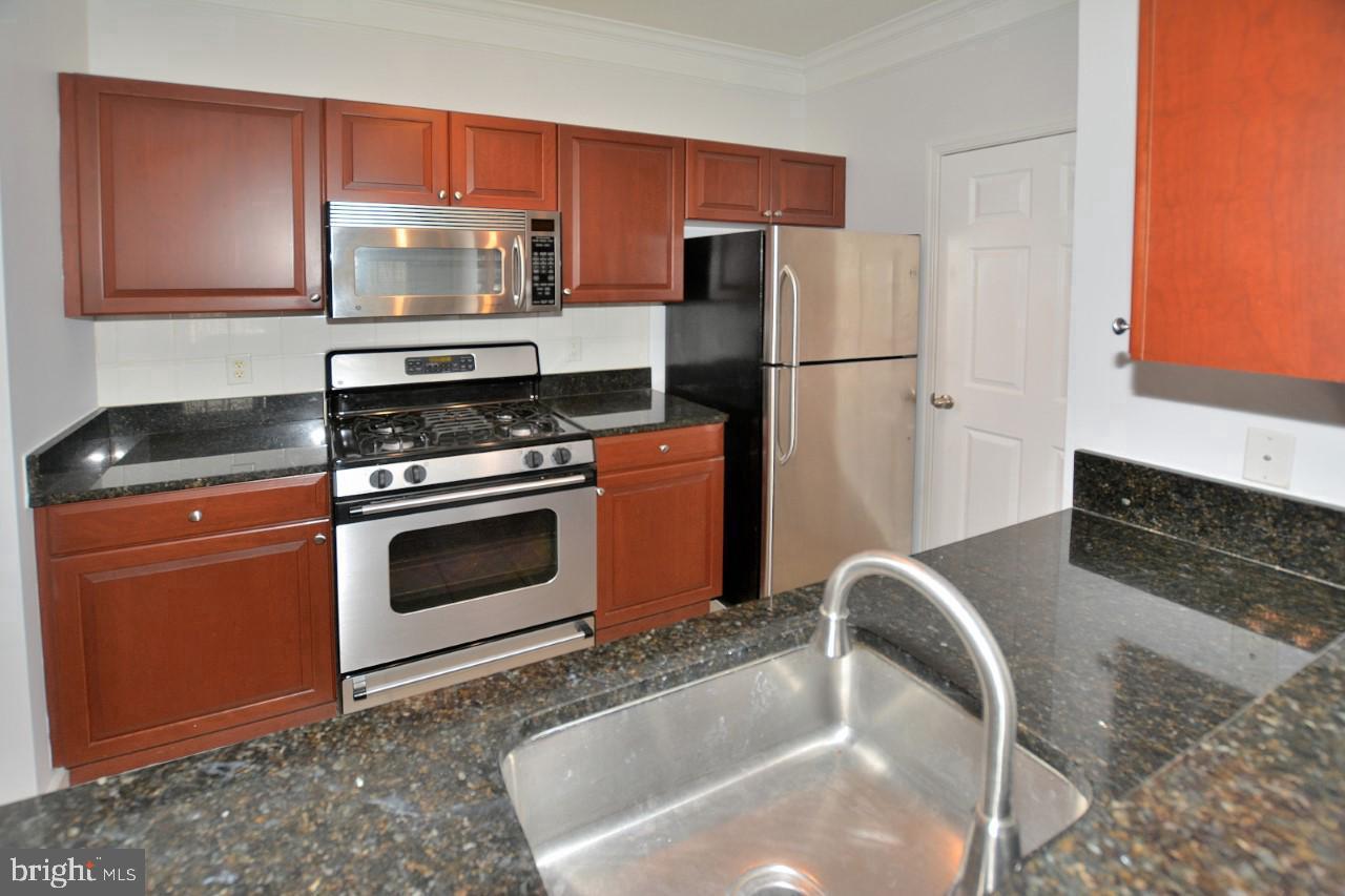 508 Sunset View Terrace Southeast, Unit 205 Leesburg, VA 20175 - Photo 13 of 28 a kitchen with stainless steel appliances granite countertop a stove a refrigerator and a sink