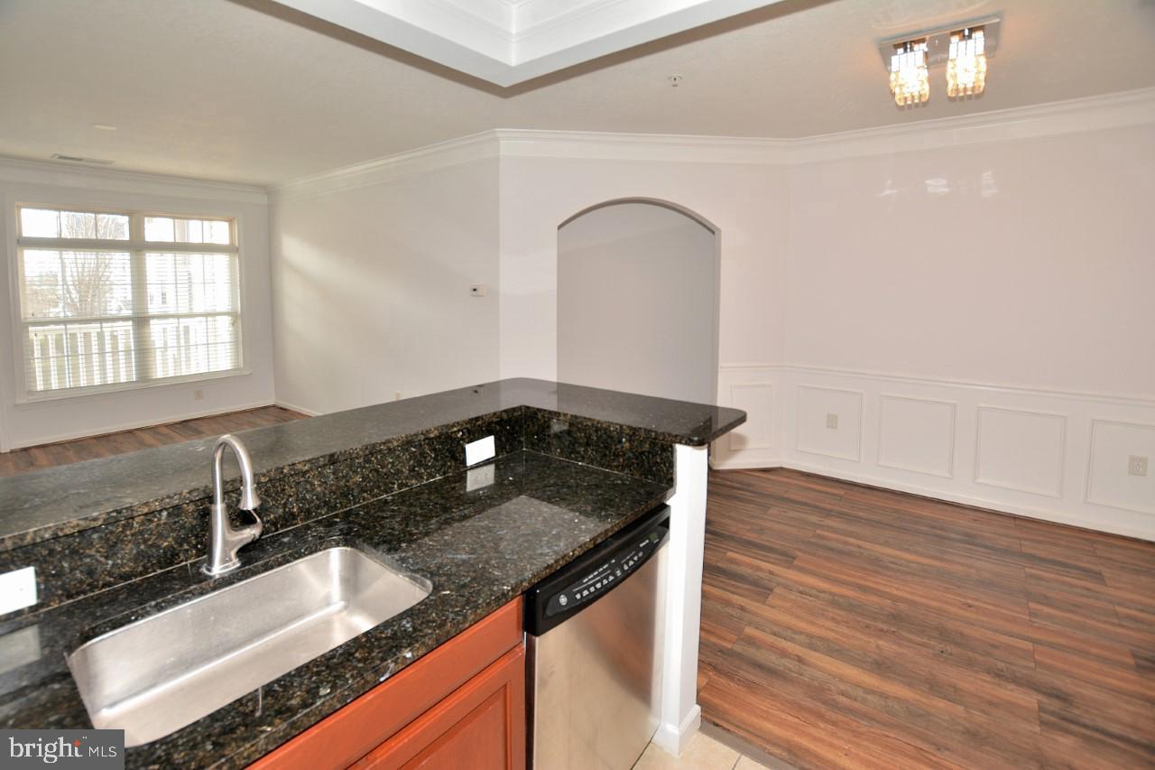 508 Sunset View Terrace Southeast, Unit 205 Leesburg, VA 20175 - Photo 16 of 28 a kitchen with granite countertop a sink and a stove top oven