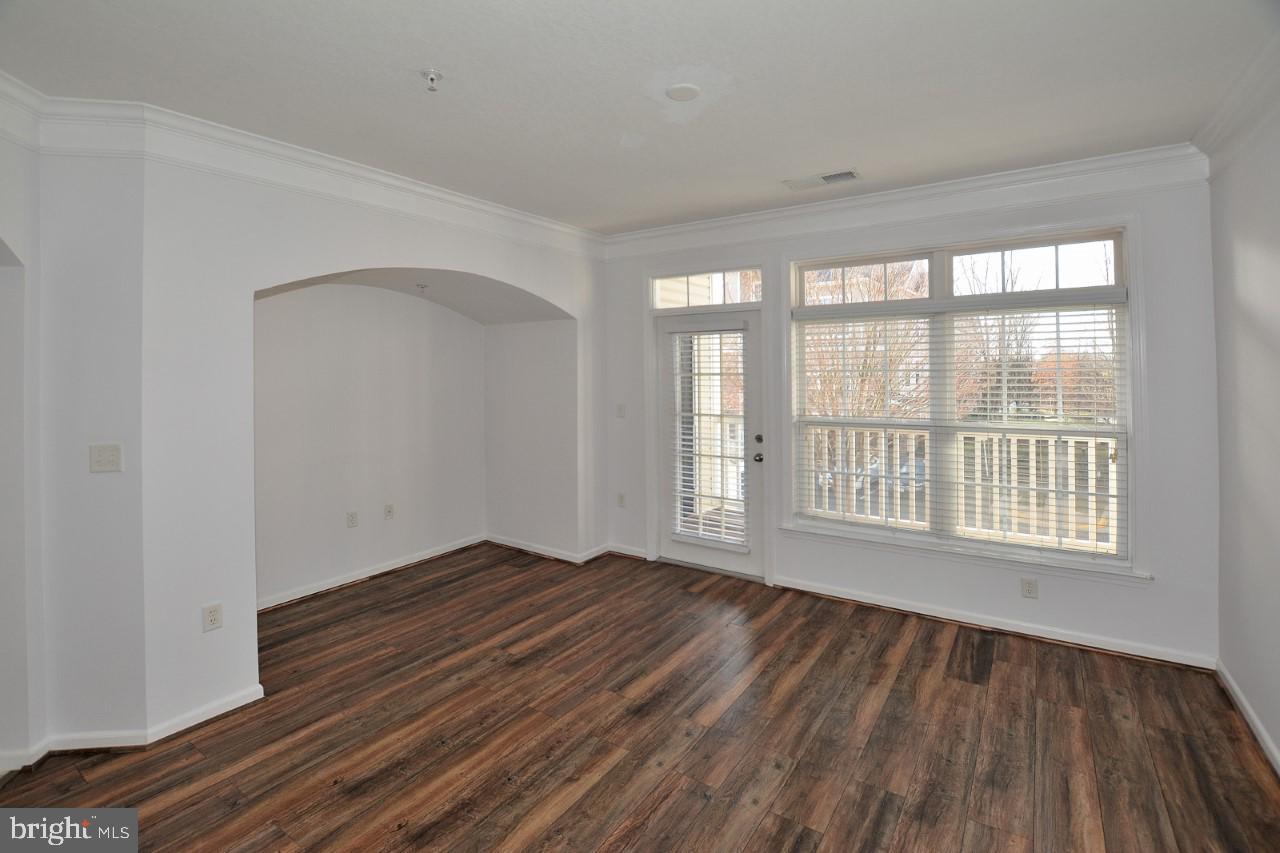 508 Sunset View Terrace Southeast, Unit 205 Leesburg, VA 20175 - Photo 20 of 28 a view of an empty room with wooden floor and a window