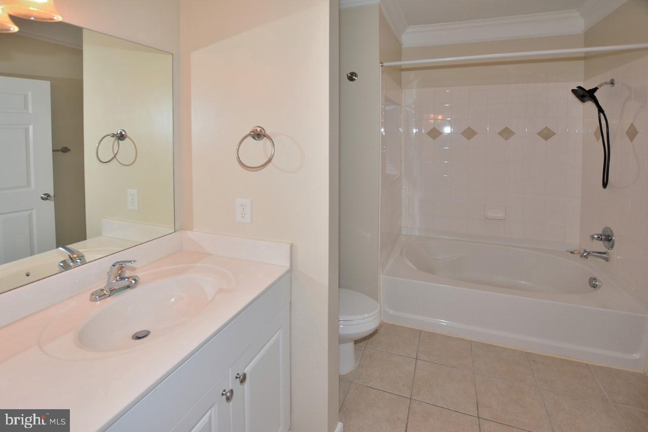 508 Sunset View Terrace Southeast, Unit 205 Leesburg, VA 20175 - Photo 21 of 28 a bathroom with a bathtub shower sink vanity and a mirror