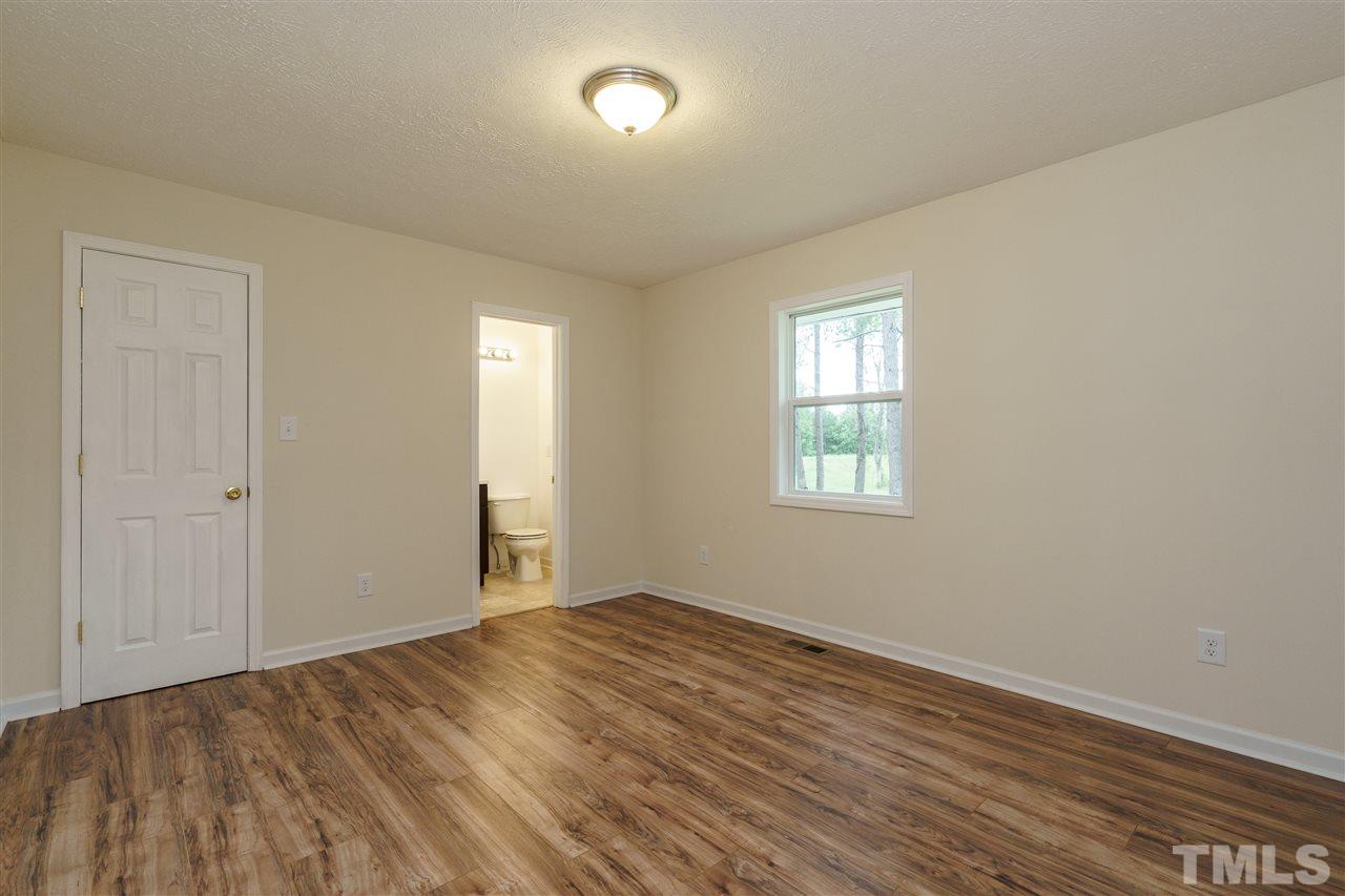 1421 Creech Road Garner, NC 27529 - Photo 11 of 23 an empty room with wooden floor and windows