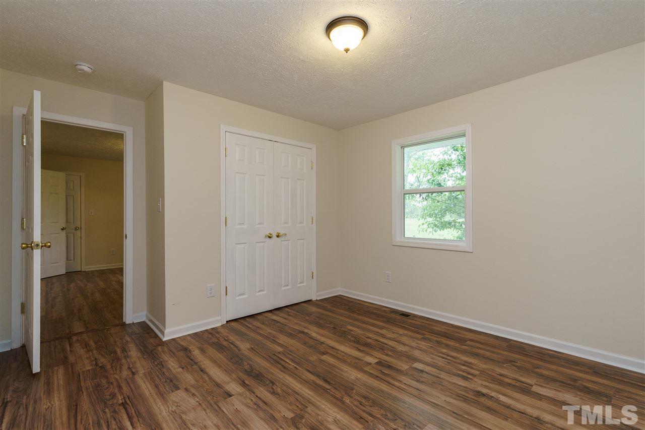1421 Creech Road Garner, NC 27529 - Photo 13 of 23 an empty room with wooden floor and windows
