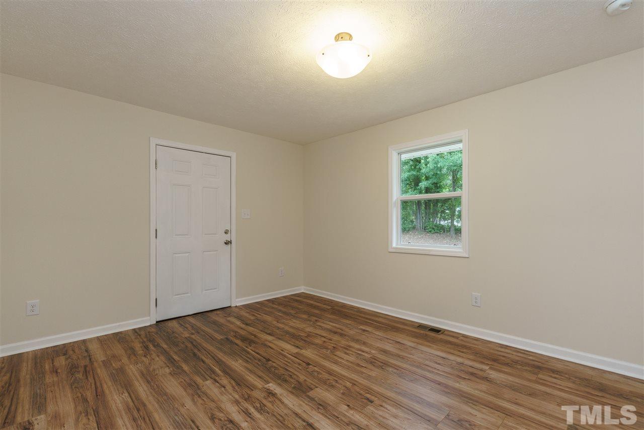 1421 Creech Road Garner, NC 27529 - Photo 14 of 23 an empty room with wooden floor and windows