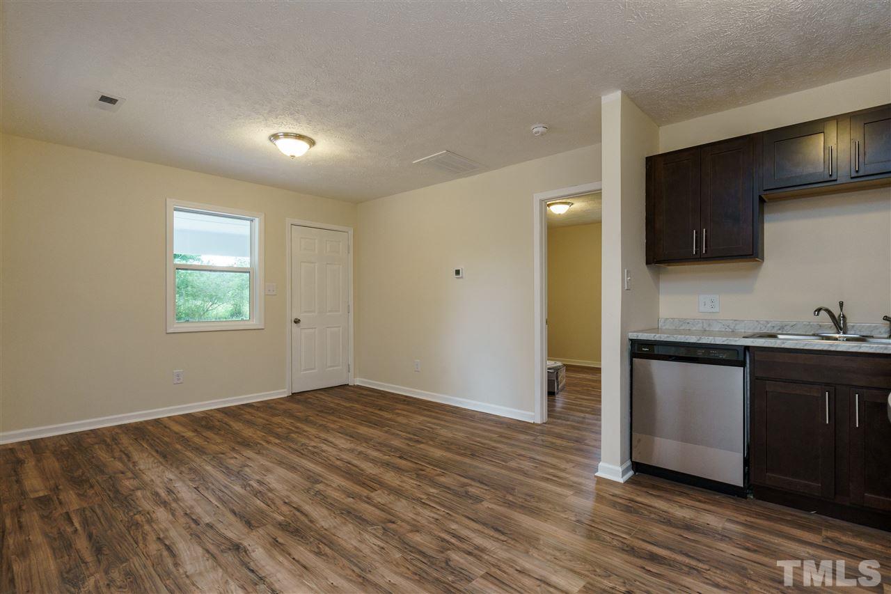 1421 Creech Road Garner, NC 27529 - Photo 16 of 23 a kitchen with granite countertop a sink cabinets and wooden floor