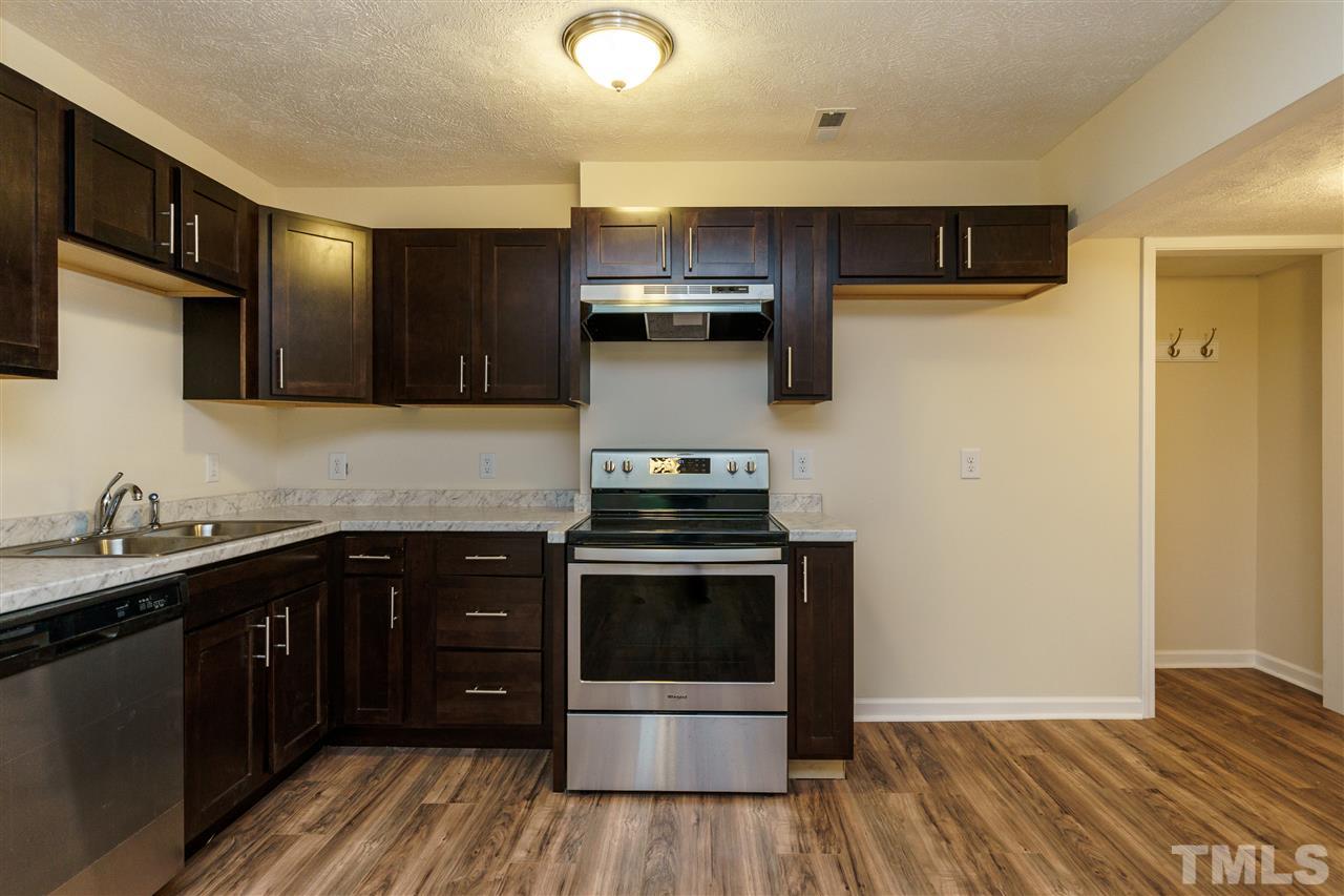 1421 Creech Road Garner, NC 27529 - Photo 19 of 23 a kitchen with a sink a stove and cabinets