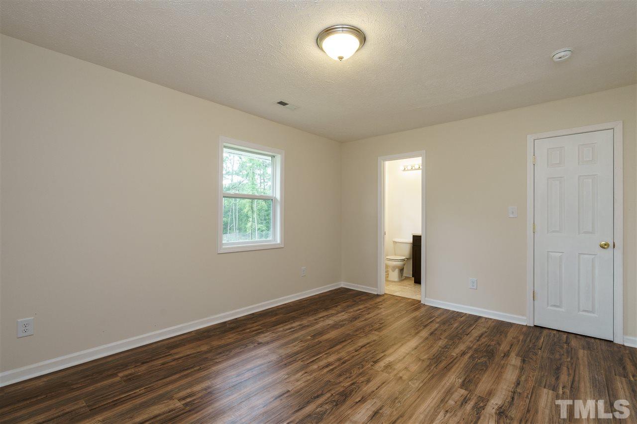 1421 Creech Road Garner, NC 27529 - Photo 21 of 23 an empty room with wooden floor and windows