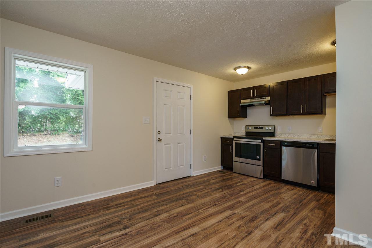 1421 Creech Road Garner, NC 27529 - Photo 6 of 23 a kitchen with granite countertop a refrigerator stove top oven and sink