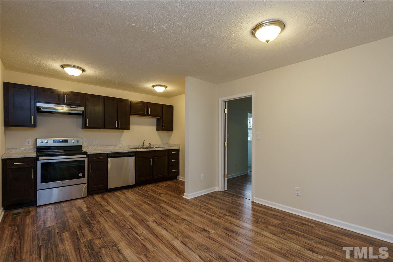 1421 Creech Road Garner, NC 27529 - Photo 7 of 23 a large kitchen with stainless steel appliances granite countertop a stove a sink and a refrigerator