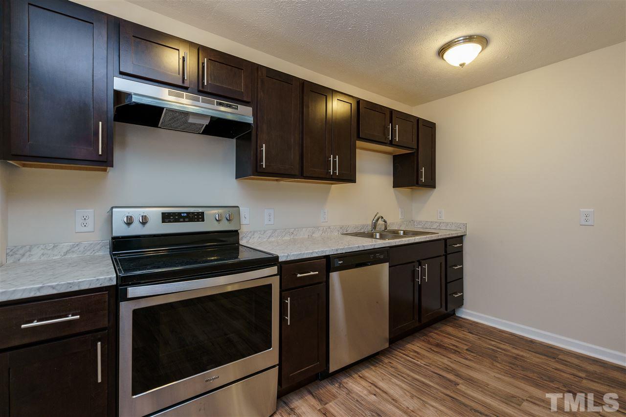 1421 Creech Road Garner, NC 27529 - Photo 9 of 23 a kitchen with stainless steel appliances a stove microwave and sink