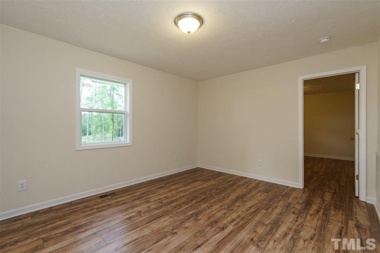 1421 Creech Road Garner, NC 27529 - Photo 10 of 23 an empty room with wooden floor and windows