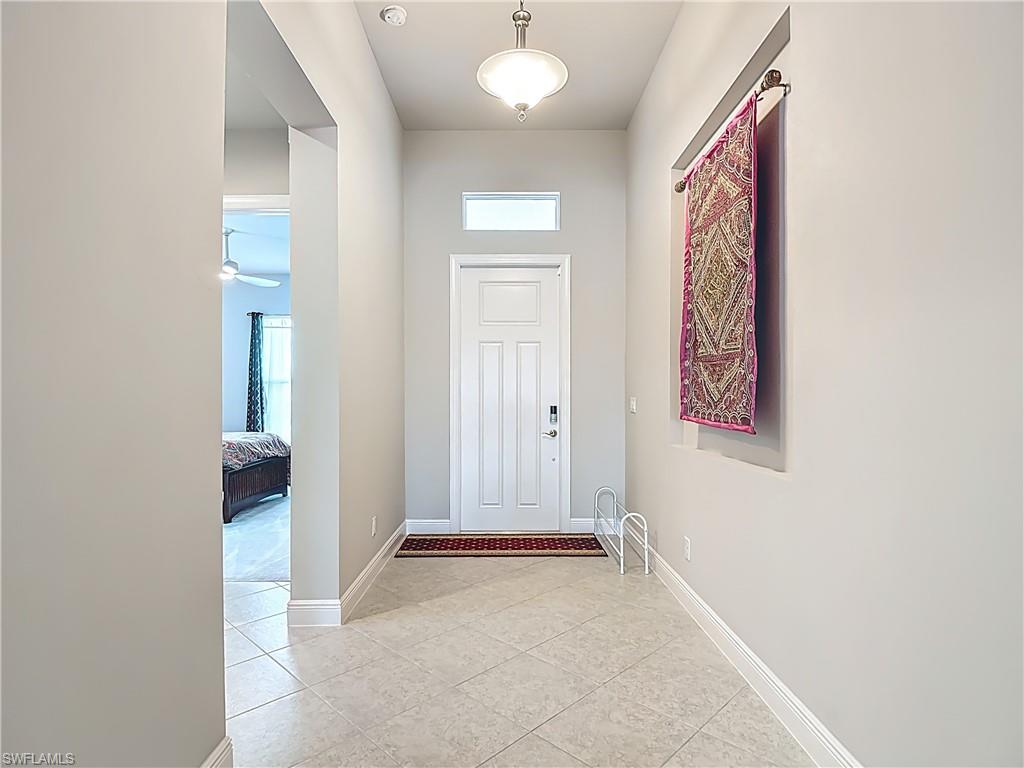 8980 Mustique Lane Naples, FL 34114 - Photo 16 of 50 Doorway to outside with tile patterned flooring and ceiling fan