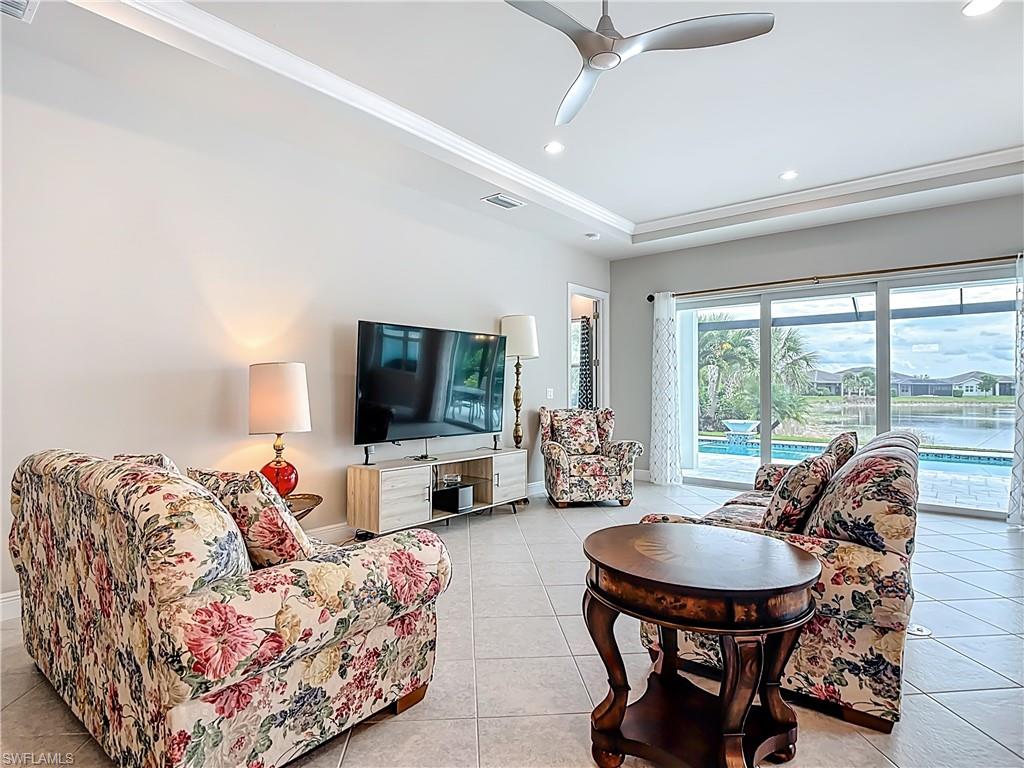 8980 Mustique Lane Naples, FL 34114 - Photo 23 of 50 Living area with recessed lighting, light tile patterned floors, ceiling fan, and a tray ceiling
