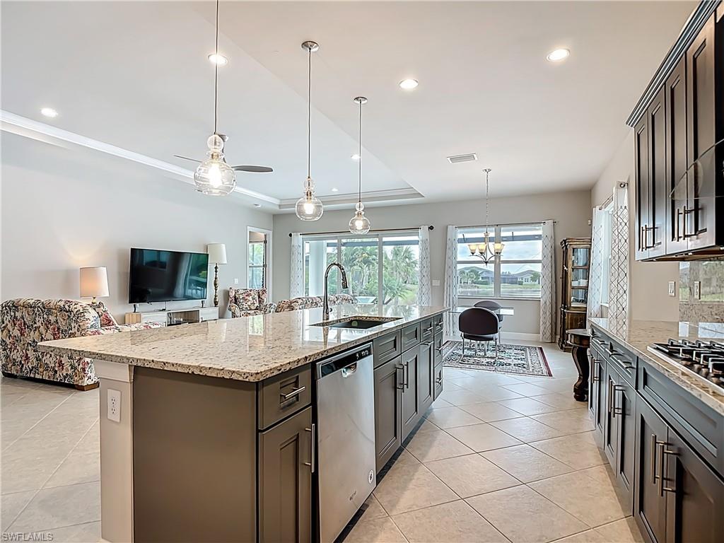 8980 Mustique Lane Naples, FL 34114 - Photo 49 of 50 Kitchen with pendant lighting, light stone counters, open floor plan, stainless steel appliances, and recessed lighting