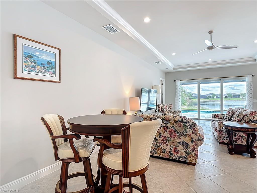 8980 Mustique Lane Naples, FL 34114 - Photo 25 of 50 Dining room with light tile patterned flooring, recessed lighting, a raised ceiling, ceiling fan, and ornamental molding