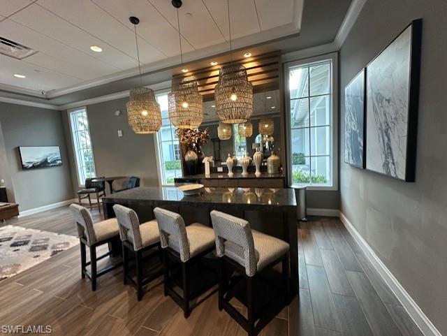 8980 Mustique Lane Naples, FL 34114 - Photo 42 of 50 Bar area with decorative light fixtures, crown molding, recessed lighting, a chandelier, and dark stone countertops