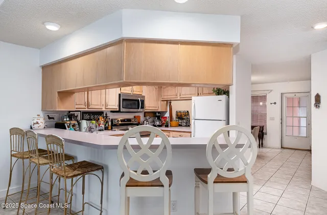 a kitchen with stainless steel appliances dining table and chairs
