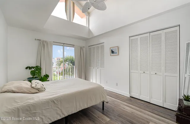 a bedroom with a large bed and wooden floor