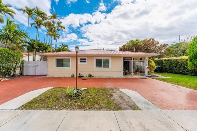 a backyard of a house with table and chairs under an umbrella