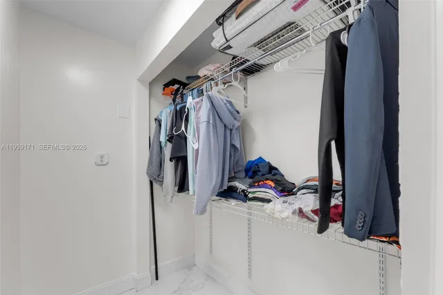 a view of walk in closet with clothes