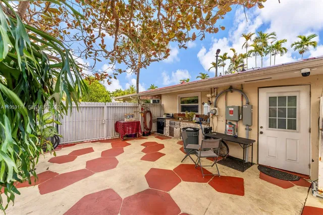 a view of a patio with table and chairs potted plants and large tree