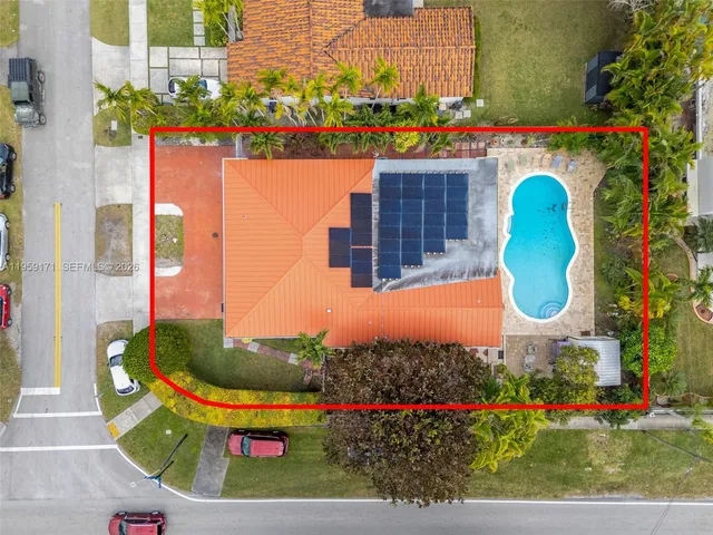 a view of a swimming pool with a yard and plants