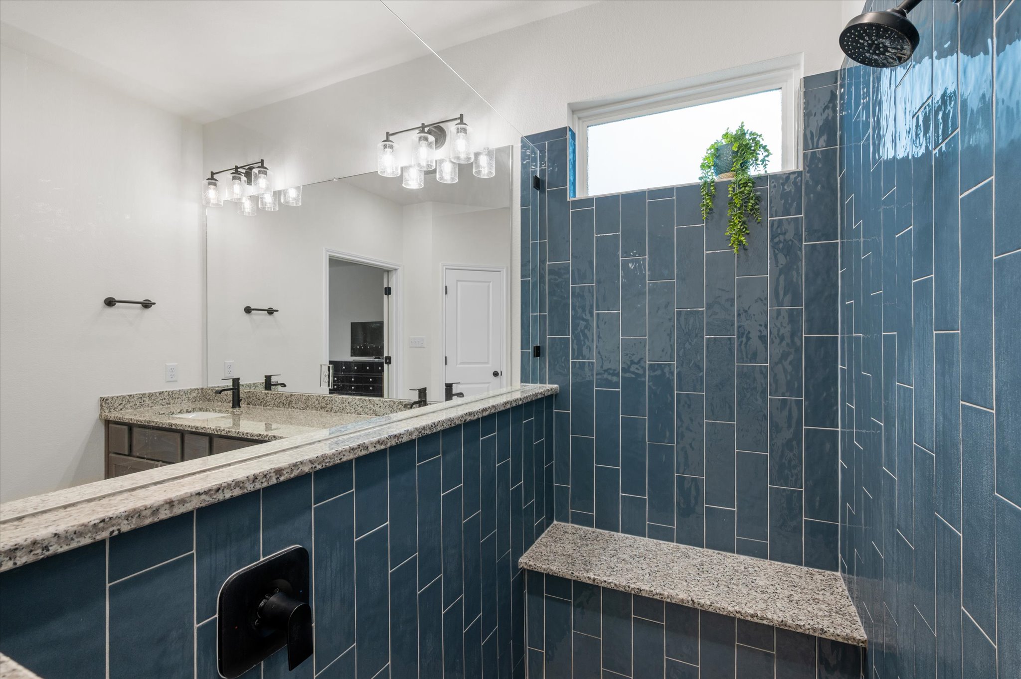 111 Beryl Way Dripping Springs, TX 78620 - Photo 11 of 26 a bathroom with a granite countertop sink a toilet a mirror and shower
