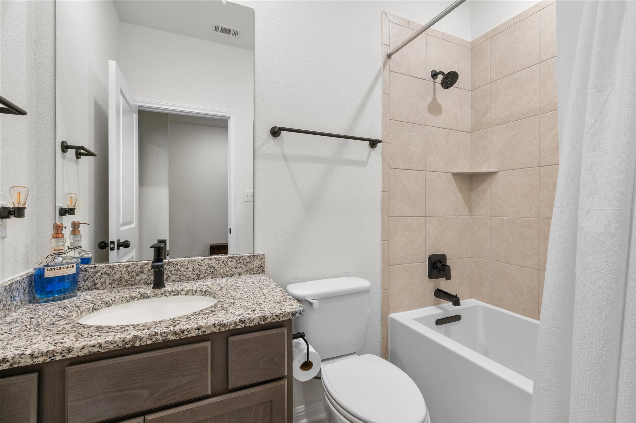 111 Beryl Way Dripping Springs, TX 78620 - Photo 14 of 26 a bathroom with a granite countertop sink toilet and shower