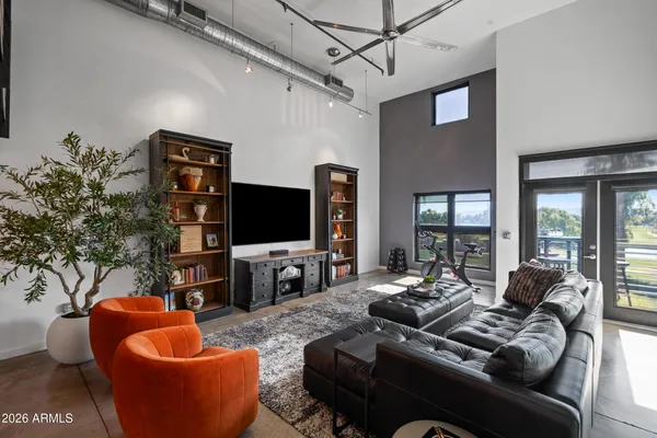 a living room with furniture a flat screen tv and a large window