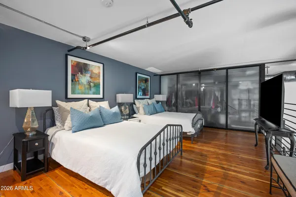 a bedroom with two beds and wooden floor