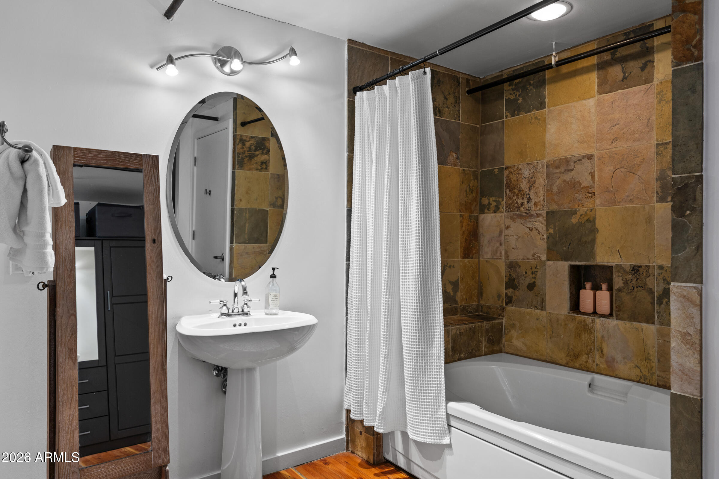 914 East Osborn Road, Unit 403 Phoenix, AZ 85014 - Photo 39 of 49 a bathroom with a sink a mirror with bathtub