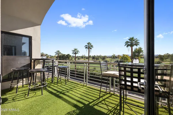a view of a lake from a balcony with furniture