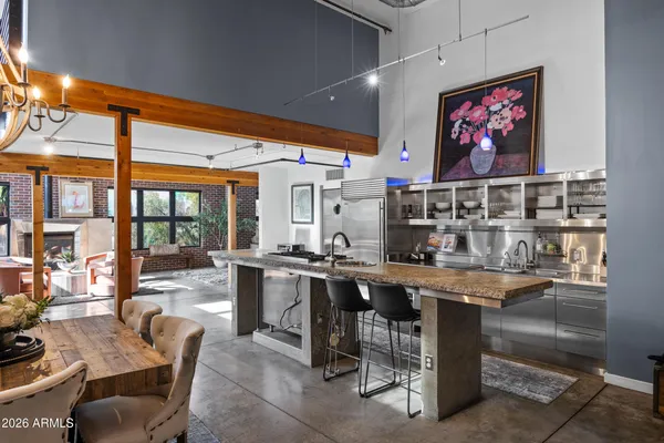 a room with stainless steel appliances lots of wooden furniture