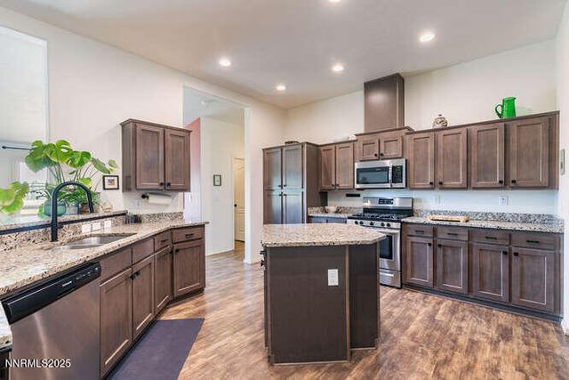 a kitchen with stainless steel appliances granite countertop a stove a sink dishwasher a refrigerator and a oven